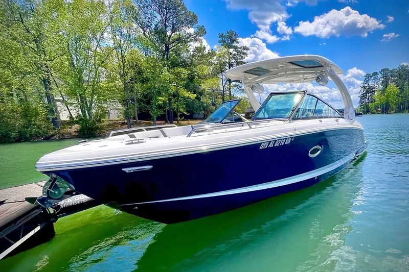 The Image of 2023 Chaparral 307 SSX boat on a serene lake with lush greenery. - 1