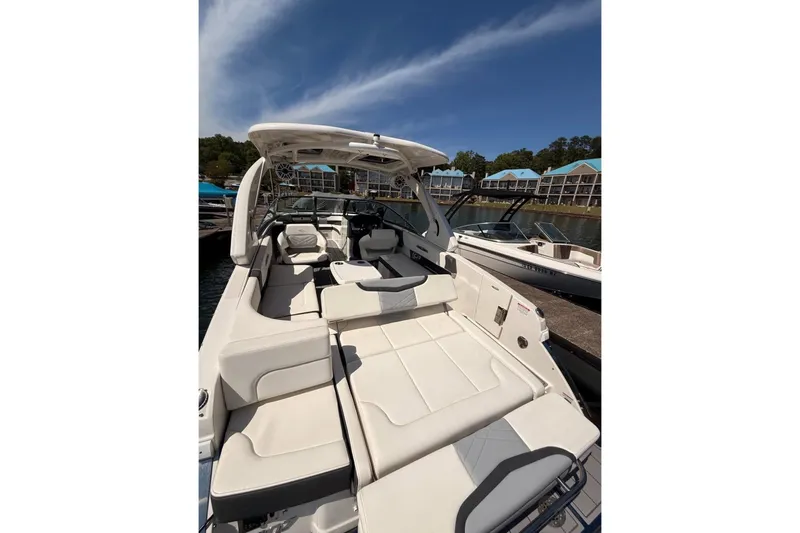 Slide: The Image of 2023 Chaparral 307 SSX boat with luxurious seating, docked near waterfront buildings. - 3