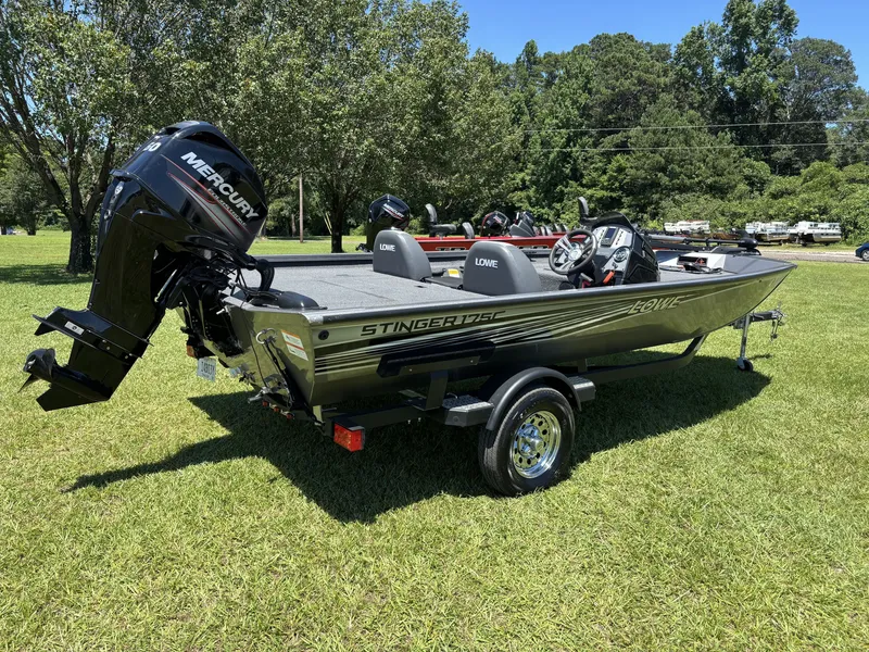 Slide: The Image of A 2018 Lowe Stinger 178 boat on a trailer on a grassy field. - 5