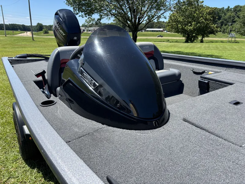 Slide: The Image of A 2018 Lowe Stinger 178 boat on grass. It features a black motor and gray seats. - 9
