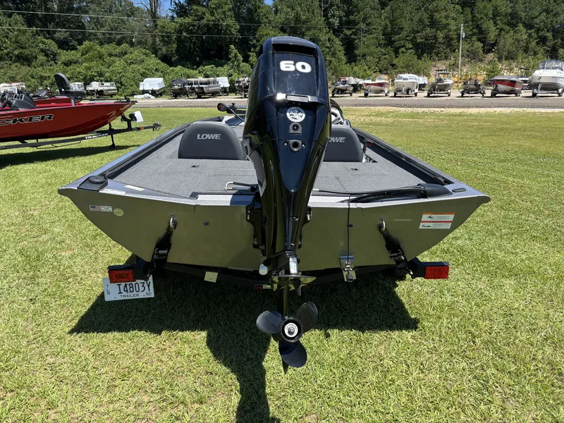 Slide: The Image of A 2018 Lowe Stinger 178 boat on grass, featuring an outboard motor. - 8