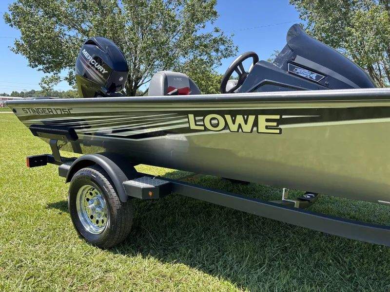 Slide: The Image of A 2018 Lowe Stinger 178 boat on a trailer, parked on grass. - 7