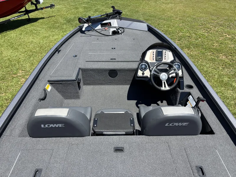 Slide: The Image of 2018 Lowe Stinger 178 with gray interior and two seats, parked on grass. - 13