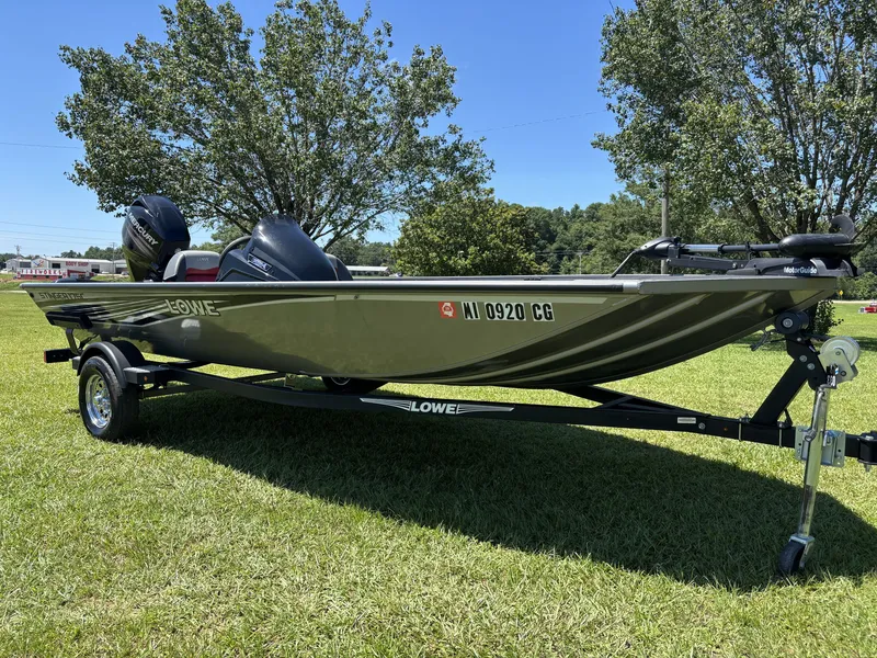Slide: The Image of A 2018 Lowe Stinger 178 boat on a trailer, set on a grassy field. - 3