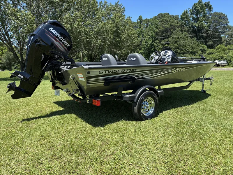 Slide: The Image of A 2018 Lowe Stinger 178 boat on a trailer on a grassy field. - 4