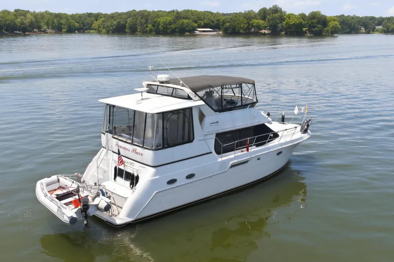 Slide: The Image of A white 2000 Carver 406 Aft Cabin Motor Yacht on a calm lake. - 3