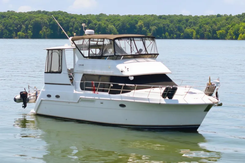 Slide: The Image of A white 2000 Carver 406 Aft Cabin Motor Yacht floats on a calm lake. - 7