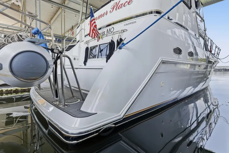 Slide: The Image of 2000 Carver 406 Aft Cabin Motor Yacht docked, featuring sleek design and American flag. - 31