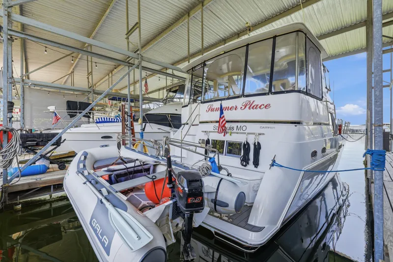 Slide: The Image of Carver 406 Aft Cabin Motor Yacht 2000 docked with inflatable boat, covered marina. - 30