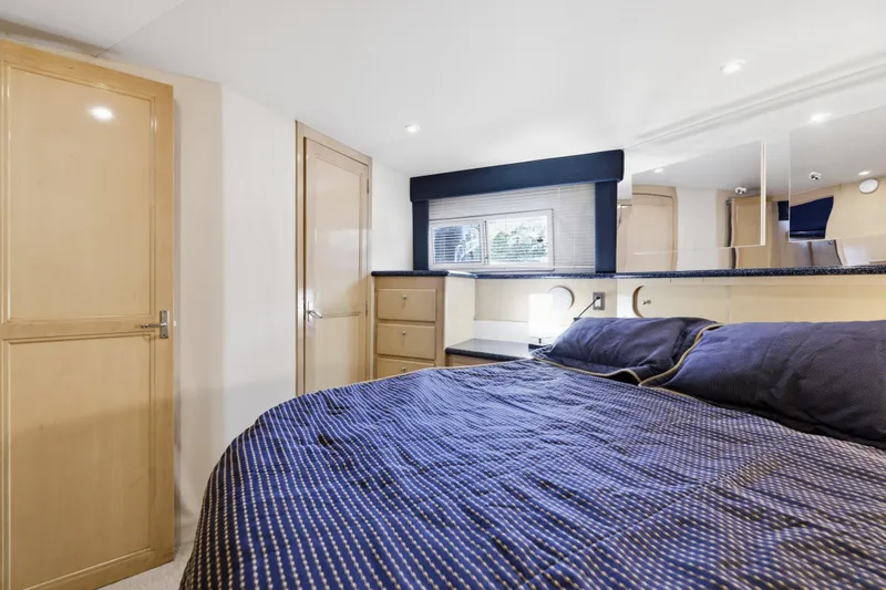 Slide: The Image of Interior of 2000 Carver 406 Aft Cabin Motor Yacht bedroom with blue bedding. - 64