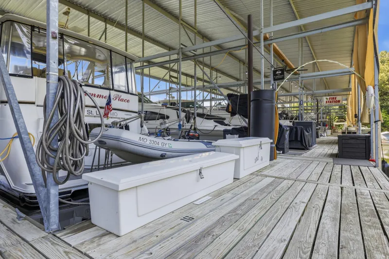 Slide: The Image of 2000 Carver 406 Aft Cabin Motor Yacht docked in covered marina with storage boxes. - 37