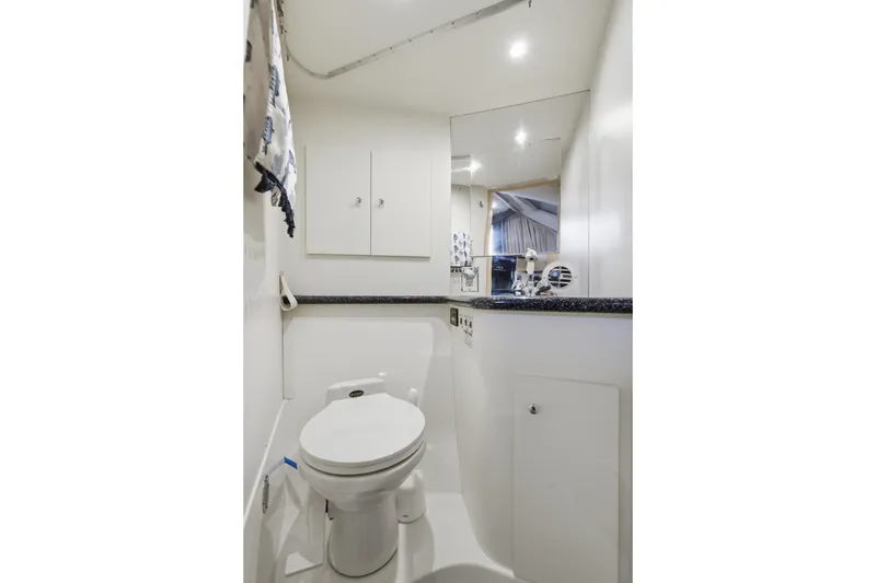 Slide: The Image of Bathroom interior of 2000 Carver 406 Aft Cabin Motor Yacht, featuring toilet and mirror. - 57