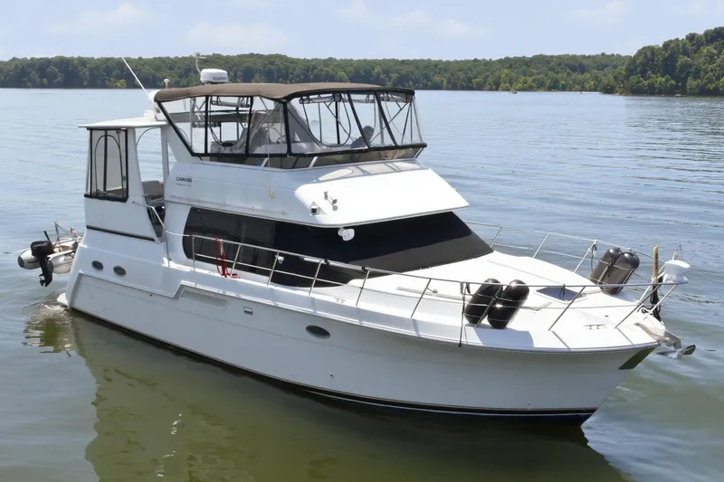 Slide: The Image of The 2000 Carver 406 Aft Cabin Motor Yacht is pictured on a calm lake. - 6