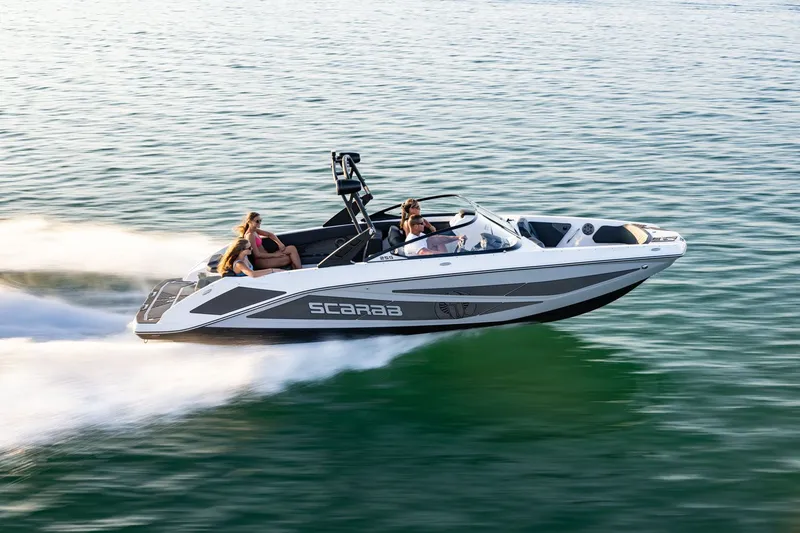 Slide: The Image of A 2026 Scarab 255 LX speeding across the water with several people on board. - 14