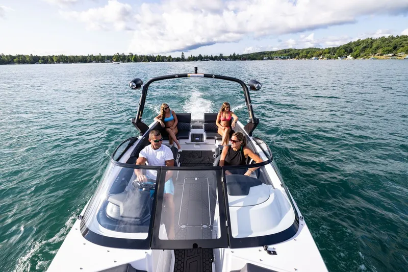 Slide: The Image of Four people relax on a Scarab 255 LX boat on a lake. - 17