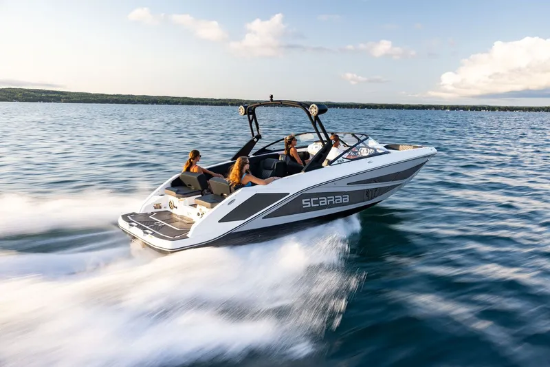 Slide: The Image of Scarab 255 LX from 2026 speeding across the water with three people on board. - 15