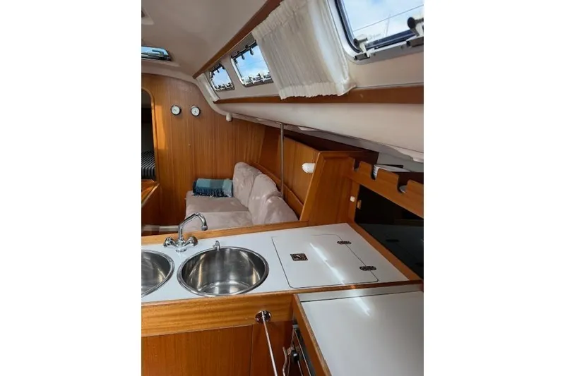 Slide: The Image of Interior of 2000 X-Yachts X-362 Sport, featuring a cozy cabin and kitchenette. - 14