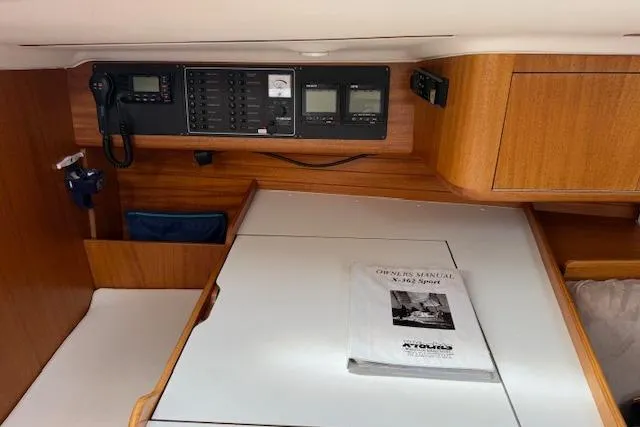 Slide: The Image of Interior of 2000 X-Yachts X-362 Sport with navigation panel and manual on table. - 16