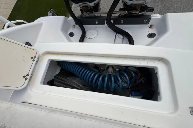 Slide: The Image of Storage compartment on a 2007 Donzi 29 ZF Open boat, featuring coiled blue hose. - 16