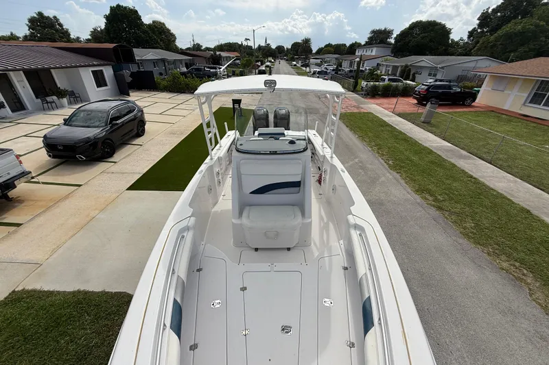 Slide: The Image of 2007 Donzi 29 ZF Open boat parked in a residential driveway, surrounded by houses and cars. - 50