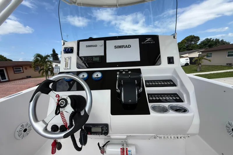 Slide: The Image of 2007 Donzi 29 ZF Open boat dashboard with steering wheel and Simrad electronics. - 23