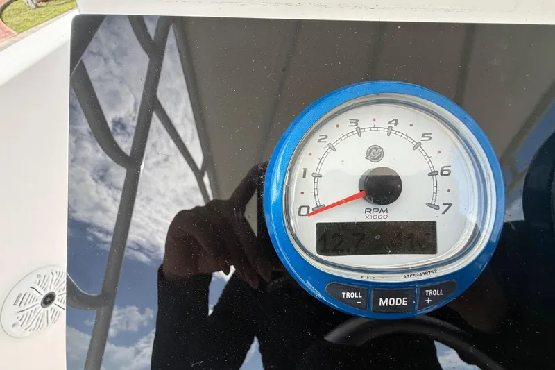Slide: The Image of RPM gauge on a 2007 Donzi 29 ZF Open boat dashboard, reflecting sky and surroundings. - 33