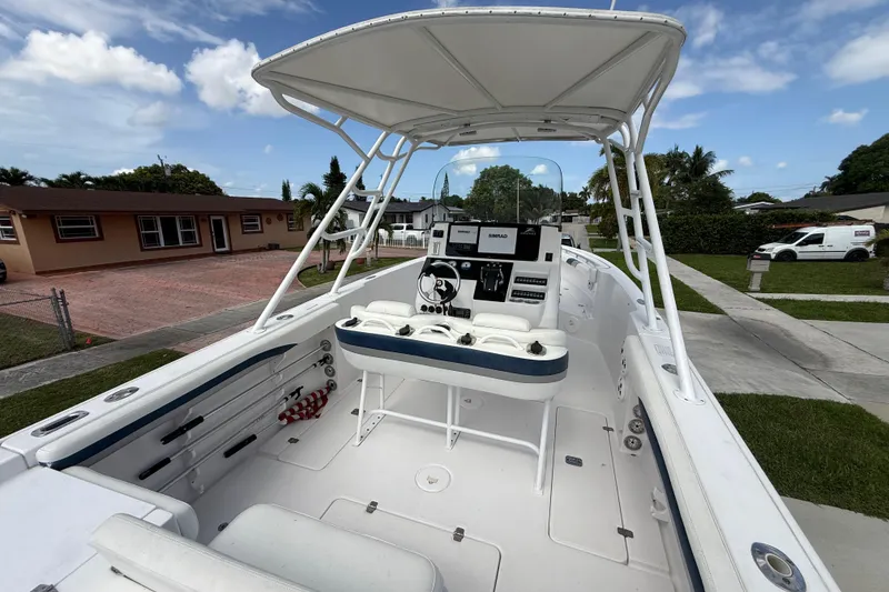 Slide: The Image of 2007 Donzi 29 ZF Open boat with T-top, parked in residential driveway under blue sky. - 7