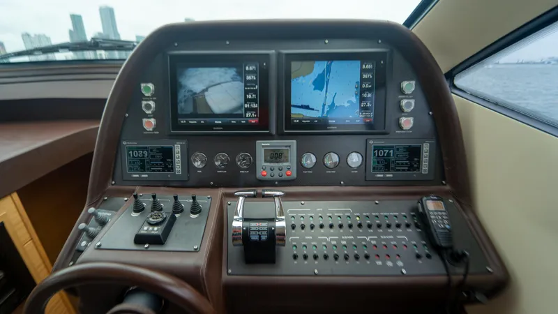 Slide: The Image of Control panel of a 2009 Pershing 64 yacht with navigation screens and controls. - 22