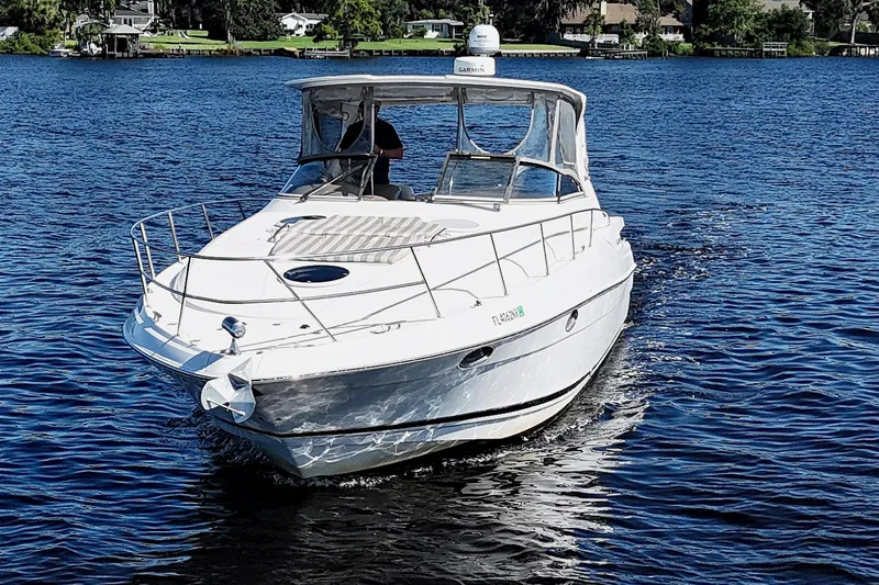 Slide: The Image of 2005 Regal Commodore 3560 IO cruising on a serene lake under clear skies. - 4