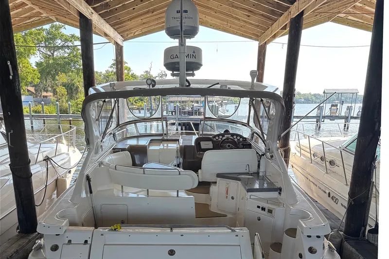 Slide: The Image of 2005 Regal Commodore 3560 IO docked under a wooden shelter, featuring a Garmin radar. - 7
