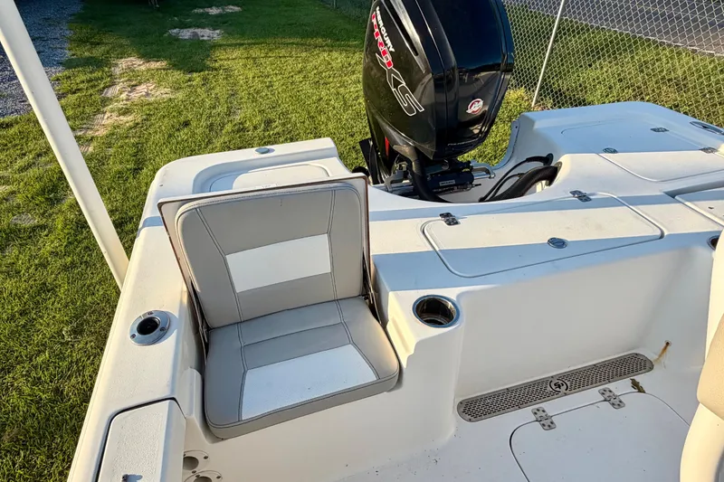 Slide: The Image of 2018 Sea Pro 208 Bay boat with seating and outboard motor, parked on grass. - 10