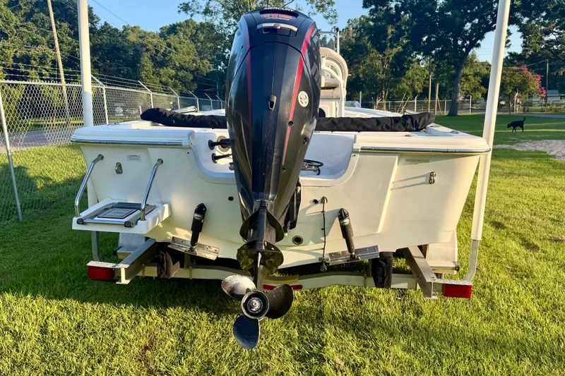 Slide: The Image of 2018 Sea Pro 208 Bay boat with outboard motor on trailer, parked on grass. - 3