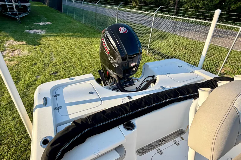 Slide: The Image of 2018 Sea Pro 208 Bay boat with powerful outboard motor, parked on grass near a fence. - 5