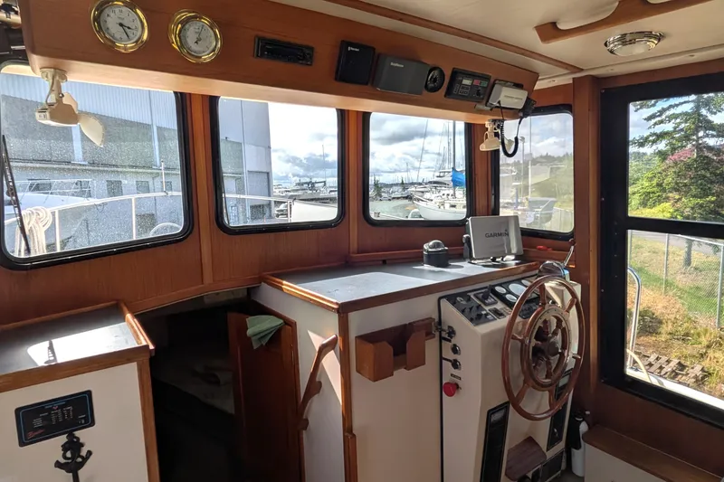 Slide: The Image of Interior of a 1998 Nordic Tug 32 boat with navigation equipment and wooden steering wheel. - 25