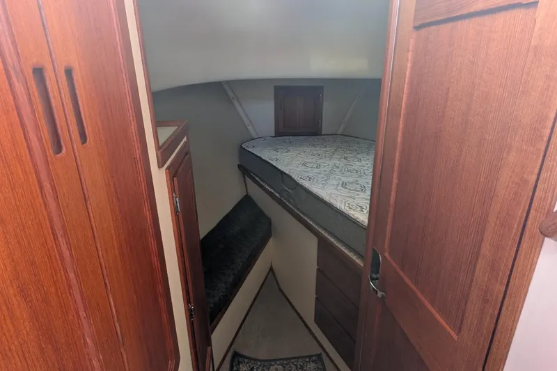 Slide: The Image of Cozy cabin interior of a 1998 Nordic Tug 32 with wooden cabinetry and a comfortable bed. - 31