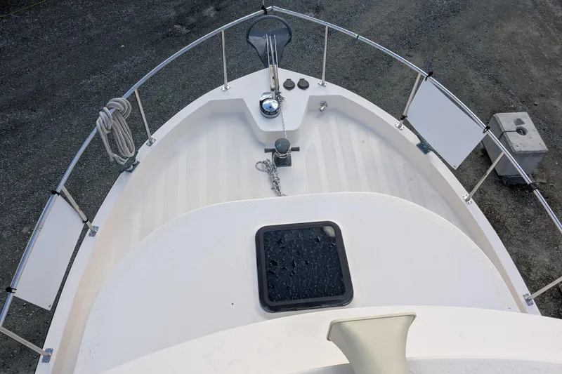 Slide: The Image of Bow view of a 1998 Nordic Tug 32, featuring deck details and railing. - 12