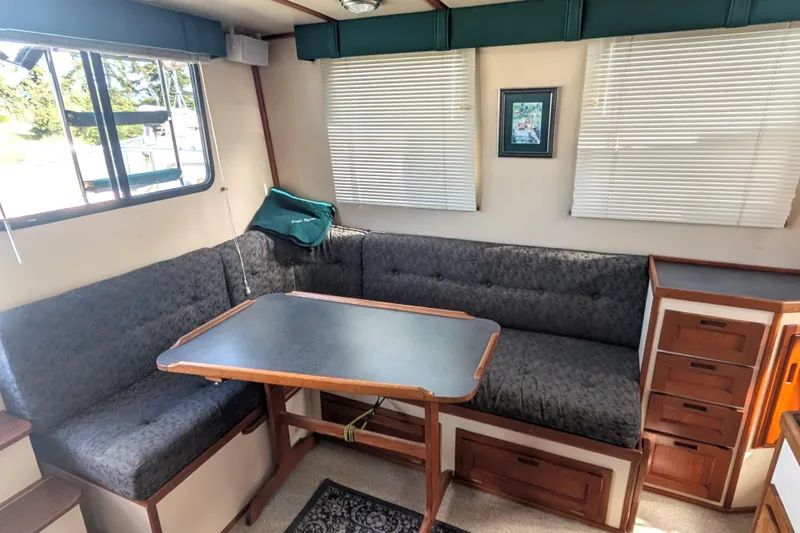 Slide: The Image of Cozy interior of a 1998 Nordic Tug 32 with a dining area and cushioned seating. - 22
