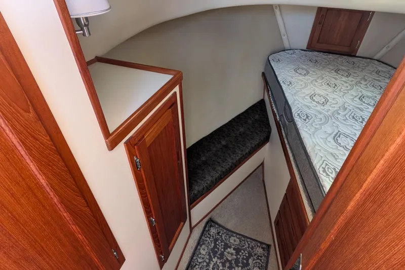 Slide: The Image of Cozy cabin interior of a 1998 Nordic Tug 32 with wood accents and patterned bedding. - 33
