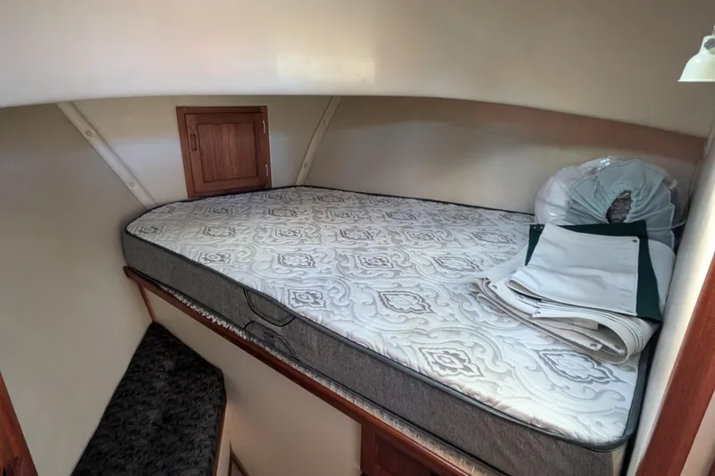 Slide: The Image of Cozy cabin interior of 1998 Nordic Tug 32 with mattress and storage. - 32