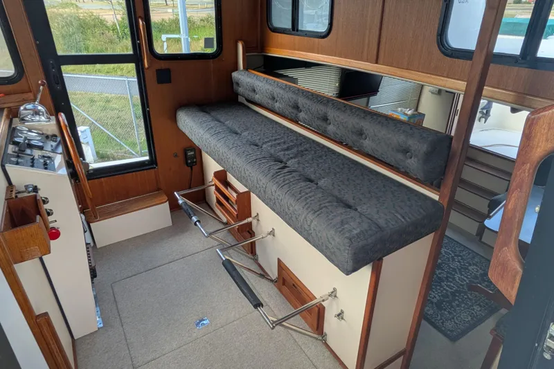 Slide: The Image of Interior of a 1998 Nordic Tug 32, featuring a cozy seating area and control panel. - 35
