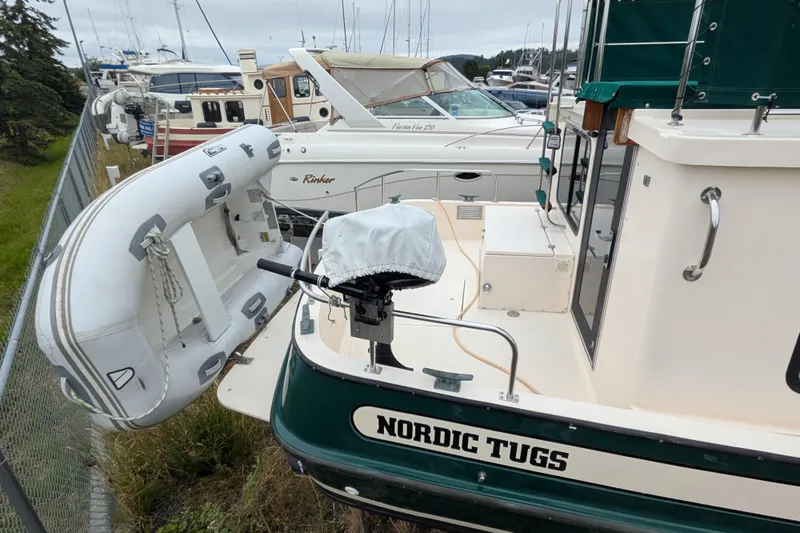 Slide: The Image of 1998 Nordic Tug 32 docked with inflatable dinghy attached at the stern. - 2