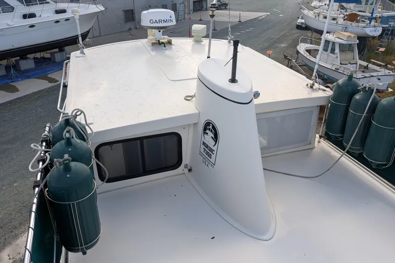 Slide: The Image of 1998 Nordic Tug 32 boat deck with Garmin equipment and fenders in a marina. - 7