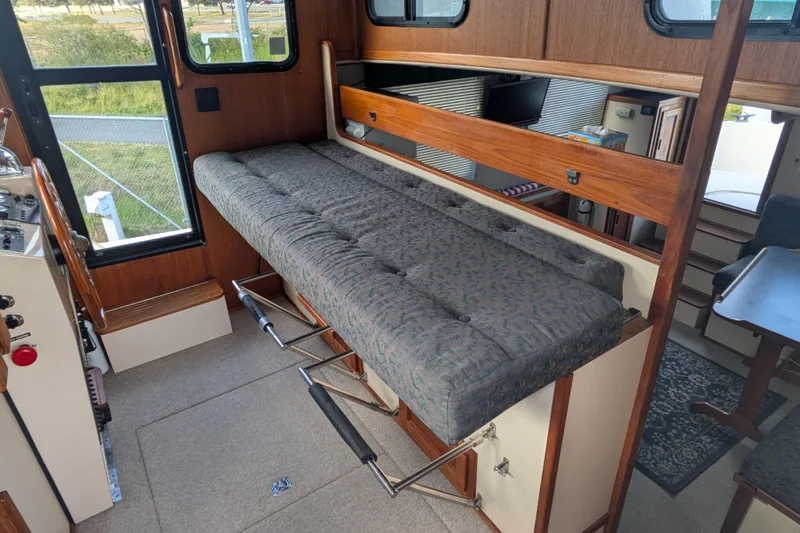 Slide: The Image of Interior of a 1998 Nordic Tug 32, featuring a fold-out cushioned bench. - 36
