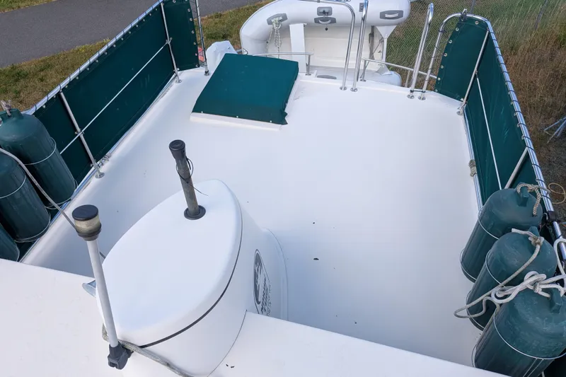 Slide: The Image of 1998 Nordic Tug 32 boat deck with green fenders and railing, featuring a clean white surface. - 11