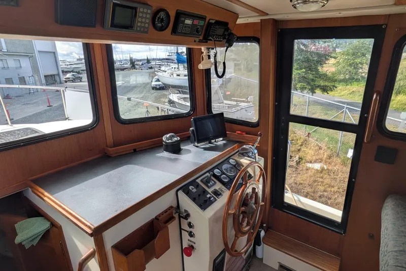 Slide: The Image of 1998 Nordic Tug 32 helm with wooden steering wheel and navigation equipment. - 26