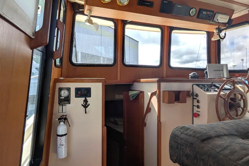 Slide: The Image of Interior of a 1998 Nordic Tug 32 boat, featuring helm and navigation equipment. - 24