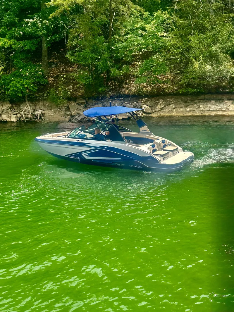 Slide: The Image of A blue and white 2016 Chaparral 223 Vortex cruising on a green lake. - 3