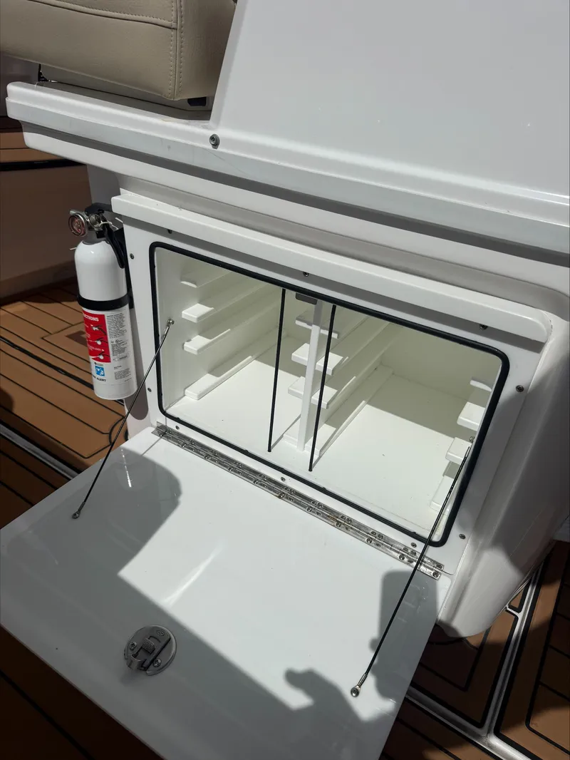 Slide: The Image of An open storage compartment on a boat with a fire extinguisher beside it. - 22