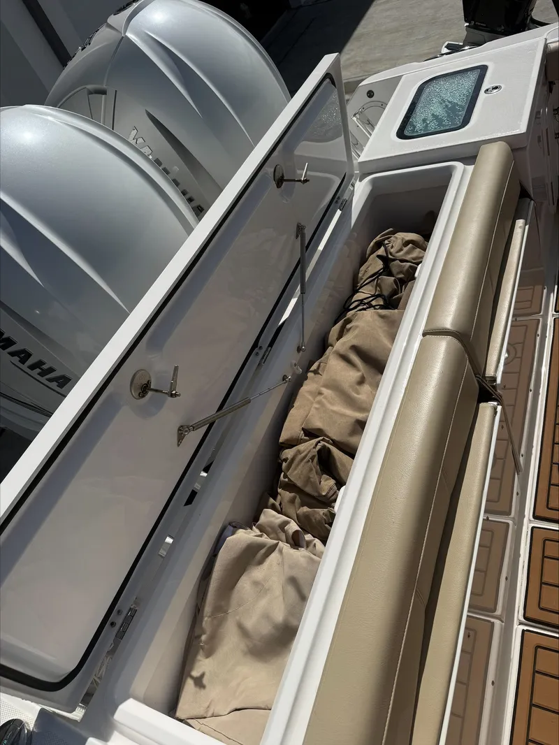 Slide: The Image of An Everglades 335 Center Console boat with storage compartment and beige upholstery. - 9