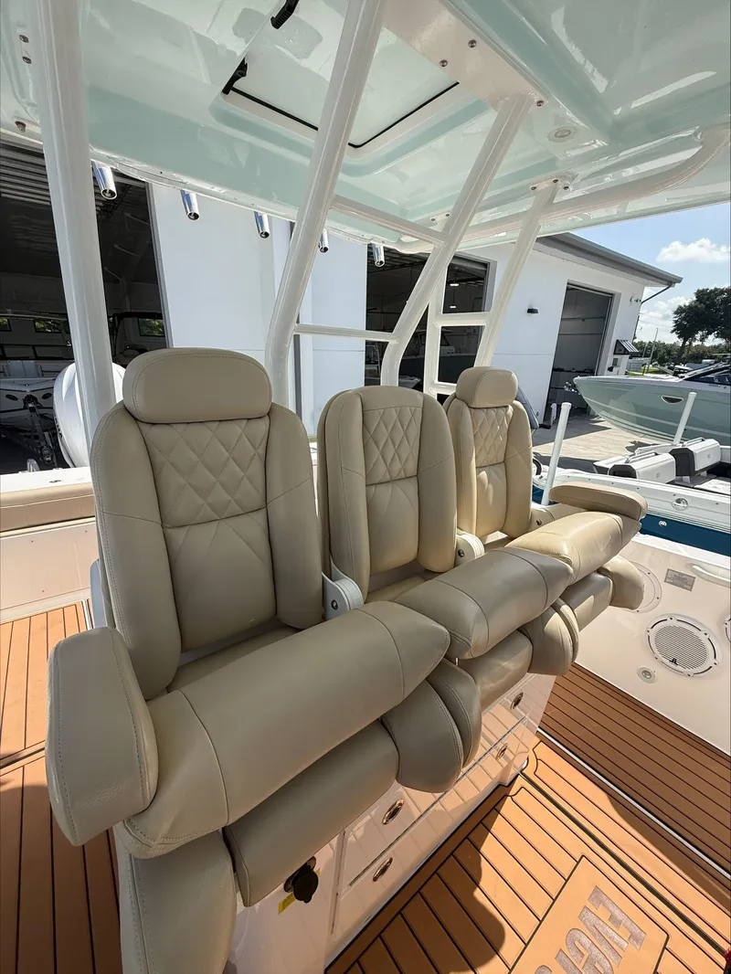 Slide: The Image of Three beige leather seats on a boat with wooden flooring and a white frame. - 23